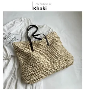 Detail of khaki woven straw tote bag with brown straps and textured rope surface
