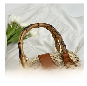Detail shot of woven straw bag featuring natural bamboo handle and leather strap accents