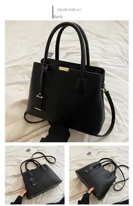 Detail of black lychee grain handbag showing gold hardware and detachable shoulder strap