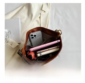 Macro view of spacious interior of brown leather tote bag with functional pockets and daily items