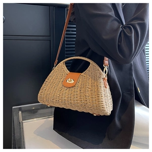 Detail der Strohtasche mit dichter Webstruktur, Lederklappe und schützenden Metallfüßen