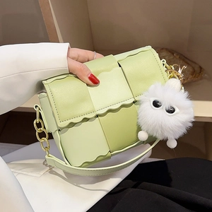 Light green woven PU leather shoulder bag with gold chain strap and fluffy monster charm