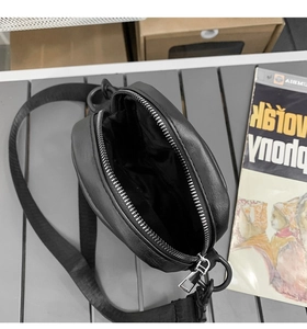 Detailed interior of the black round crossbody bag showing fabric lining and zipper closure