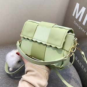 Light green woven PU leather handbag with wavy edges and a white plush charm
