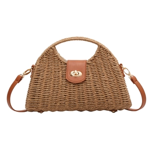 Detailansicht der Strohtasche mit brauner Lederklappe und goldenem Drehverschluss