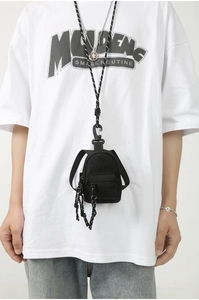 Gros plan d'un mini porte-monnaie sac à dos noir avec cordon porté par un mannequin