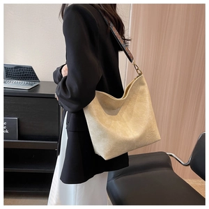 Detail of beige tote bag side view showing faux leather texture and jacquard wide strap