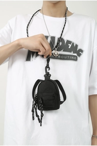 Détail d'un mini porte-clés sac à dos en toile avec cordon tressé et fermeture éclair