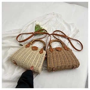 Detail of woven straw bags with bamboo handles and protective metal studs on base