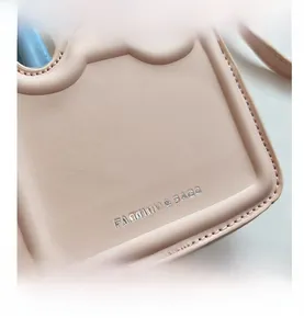 Vue détaillée du sac en cuir rose avec bords ondulés et logo de marque argenté
