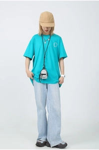Gros plan sur le mini porte-monnaie turquoise porté avec une tenue streetwear