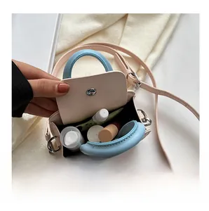Détail de l'intérieur du mini sac bicolore avec rouge à lèvres et maquillage