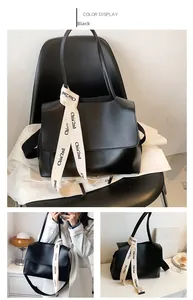 Détail du grand sac à bandoulière noir avec ruban imprimé élégant sur une chaise