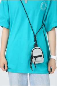 Gros plan d'une mini pochette en toile grise avec cordon sur un t-shirt vert fluo