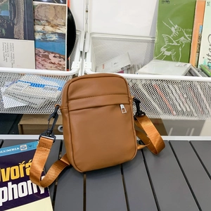 Minimalist brown crossbody phone bag with wide nylon strap and matte faux leather texture