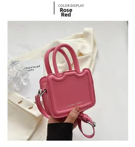 Détail du sac bandoulière rose rouge avec poignée festonnée et lettrage de mode chic