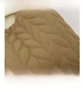 Close-up of khaki quilted tote bag featuring detailed leaf pattern stitching and nylon fabric