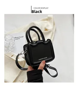 Détail du mini sac cabas noir avec doubles poignées et bandoulière amovible