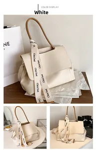 Détail du sac fourre-tout crème avec bandoulière tissée et des poignées brunes