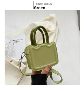 Détail du mini sac à main vert avocat avec bords ondulés et poignée circulaire