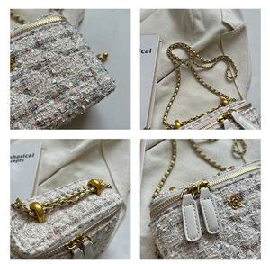 Dettaglio della borsa a tracolla in tweed con catena dorata e cursore floreale