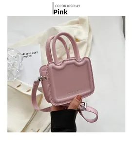 Détail du mini sac à main rose montrant la texture du cuir PU et les deux poignées
