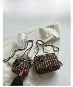 Dettaglio di borse a tracolla in tweed nero con fiori dorati e catene in metallo