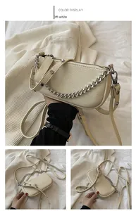 Detail view of off-white lychee pattern leather bag with silver chain and strap