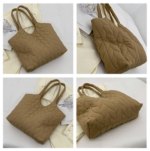 Macro details of khaki quilted puffer tote bag with leaf-pattern stitching and dual straps