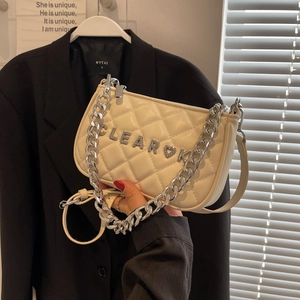 Quilted cream crossbody bag with silver chain strap and metal heart logo detail