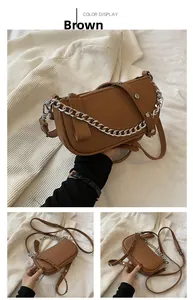 Detail of vintage brown textured leather bag featuring silver rivets and chunky chain