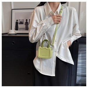 Détail du mini sac à main carré vert clair avec poignée et bandoulière réglable