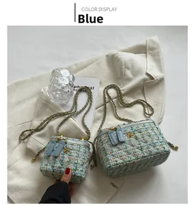 Dettaglio della borsa a tracolla in tweed con ciondoli a fiori dorati e catena