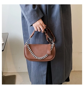 Detail of vintage brown pebble leather bag with silver chain and sleek zipper closure