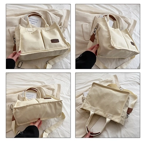 Detail view showing minimalist cream canvas tote bag with brown leather handles and pockets