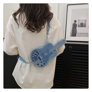 Detail of guitar-shaped denim crossbody bag with embroidery worn by a model in a room