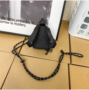 Détail d'une mini pochette triangle noire en nylon avec cordon tressé et mousqueton