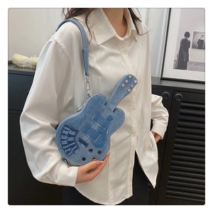 Detail of guitar-shaped denim crossbody bag with vintage embroidery and adjustable strap