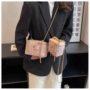 Dettaglio borse in tweed rosa con decoro a camelia in metallo e tracolla intrecciata