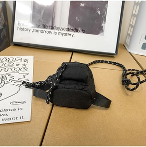 Vue détaillée du mini sac en nylon noir avec poches zippées et bandoulière tissée réglable