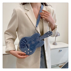 Detail of guitar shaped denim crossbody bag with metal studs and white stitching effects