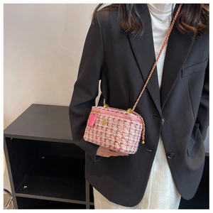Dettaglio borsa a tracolla in tweed rosa e beige con fiore dorato e catena sottile
