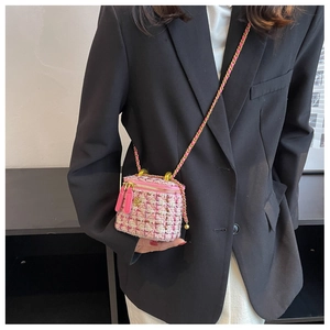 Dettagli del tessuto tweed rosa della borsa a tracolla con logo camelia dorata