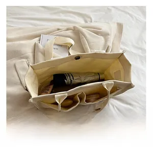 Interior view of off-white canvas tote bag showing large capacity and internal pockets