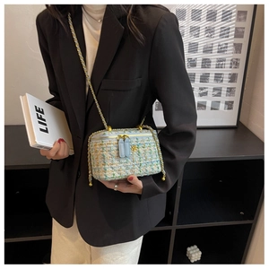 Dettaglio della borsa a tracolla in tweed colorato con logo camelia dorato su blazer
