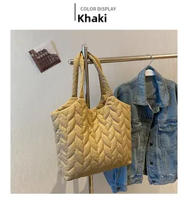 Detail view of khaki quilted tote bag with wave-patterned nylon texture and wide straps