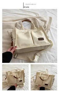 Detailed macro view of off-white canvas tote bag with front pockets and brown leather trim