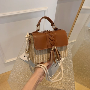 Straw saddle crossbody bag with brown leather flap and stylish tassel fringe detail