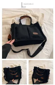 Detail of black canvas tote bag with brown handles and external pockets for daily commute