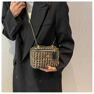 Dettaglio borsa a tracolla in tweed con hardware camelia dorata e tracolla a catena